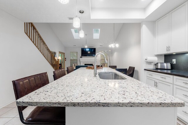308 Postage Cir, Pickerington, OH 43147 - kitchen featuring a sink, an island with sink, a kitchen bar, a skylight, and high vaulted ceiling
