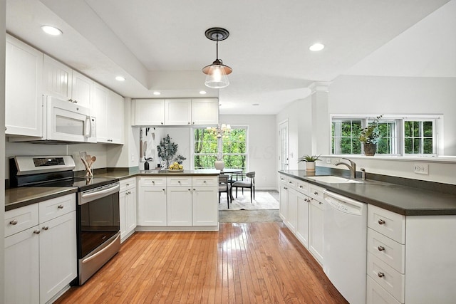 1223 Sanctuary Pl, Columbus, OH 43230 - kitchen with white appliances, dark countertops, a peninsula, white cabinetry, and recessed lighting