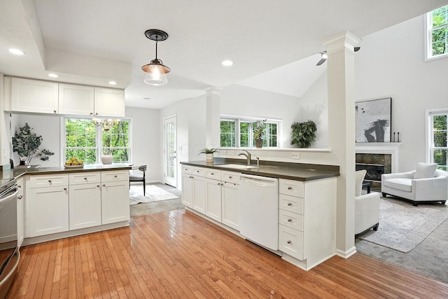 1223 Sanctuary Pl, Columbus, OH 43230 - kitchen with white dishwasher, dark countertops, ornate columns, light wood-style flooring, and recessed lighting