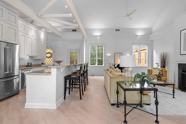 382 E Town St, Columbus, OH 43215 - kitchen with stainless steel appliances, a ceiling fan, a breakfast bar, light wood-type flooring, and beam ceiling