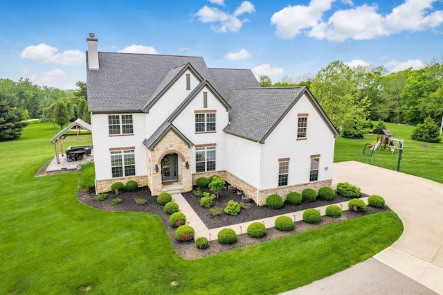 5046 Clark-Shaw Rd, Powell, OH 43065 - view of front of home featuring stone siding, stucco siding, a chimney, and a front lawn