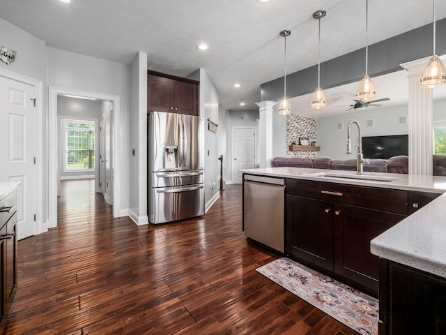 5046 Clark-Shaw Rd, Powell, OH 43065 - kitchen featuring appliances with stainless steel finishes, ornate columns, open floor plan, dark brown cabinetry, and a sink