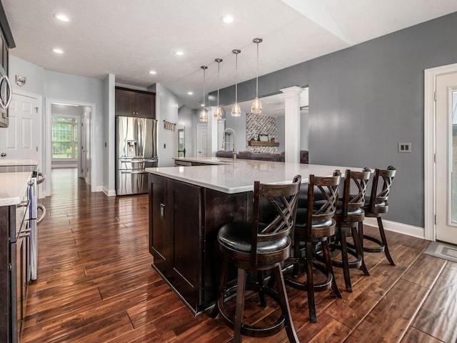 5046 Clark-Shaw Rd, Powell, OH 43065 - kitchen with stainless steel refrigerator with ice dispenser, dark brown cabinetry, light countertops, a large island, and dark wood finished floors