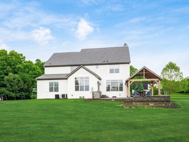 5046 Clark-Shaw Rd, Powell, OH 43065 - rear view of property featuring a gazebo, stucco siding, a lawn, a chimney, and central AC unit