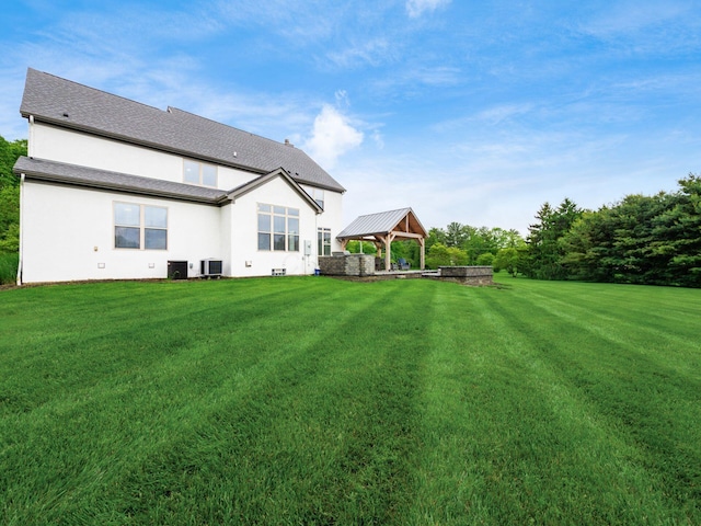 5046 Clark-Shaw Rd, Powell, OH 43065 - rear view of house featuring a gazebo, stucco siding, a yard, and central air condition unit