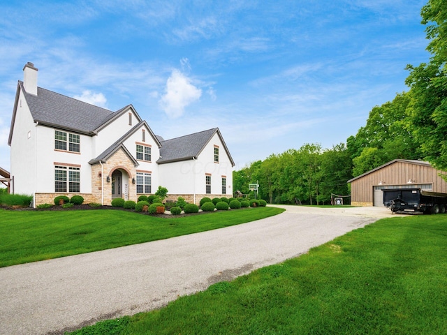 5046 Clark-Shaw Rd, Powell, OH 43065 - view of front of home with an outbuilding, a garage, a chimney, a front yard, and stucco siding