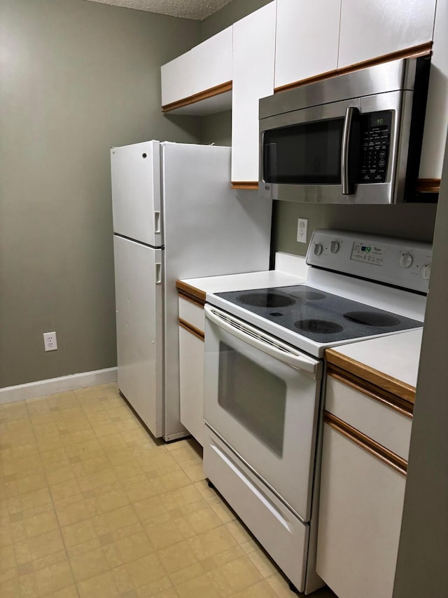 2037 Burbridge Ln Unit 31B, Hilliard, OH 43026 - kitchen featuring stainless steel microwave, electric range, white cabinetry, and light countertops