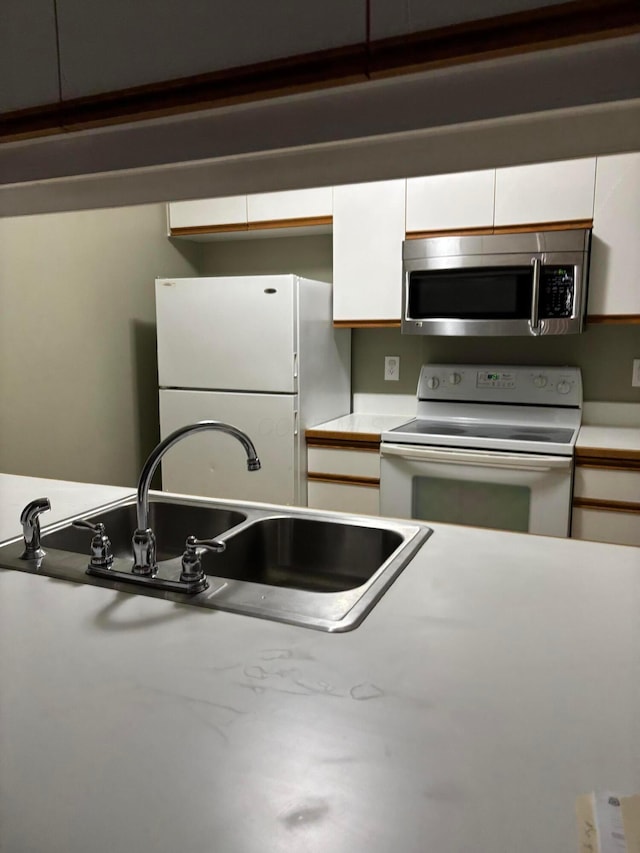 2037 Burbridge Ln Unit 31B, Hilliard, OH 43026 - kitchen featuring white appliances, a sink, white cabinetry, and light countertops