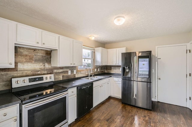 1041 Clifton Chase Dr, Galloway, OH 43119 - kitchen featuring stainless steel appliances, a sink, dark countertops, a textured ceiling, and white cabinets