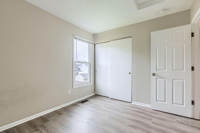 1041 Clifton Chase Dr, Galloway, OH 43119 - unfurnished bedroom with wood finished floors, baseboards, a closet, and a textured ceiling