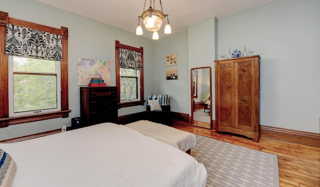 758 S Front St, Columbus, OH 43206 - bedroom featuring wood finished floors, baseboards, and a chandelier