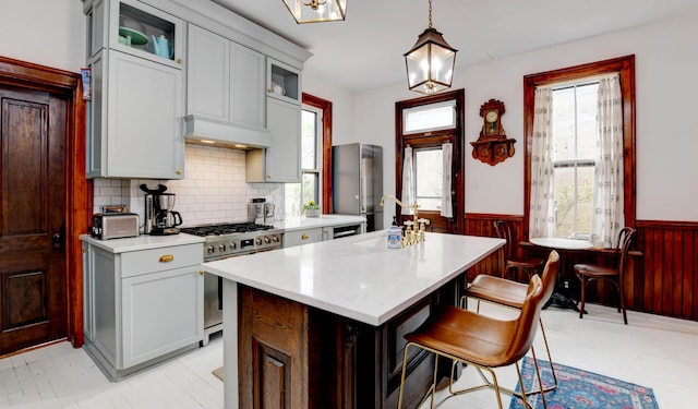 758 S Front St, Columbus, OH 43206 - kitchen with a sink, appliances with stainless steel finishes, a wainscoted wall, light countertops, and a kitchen island
