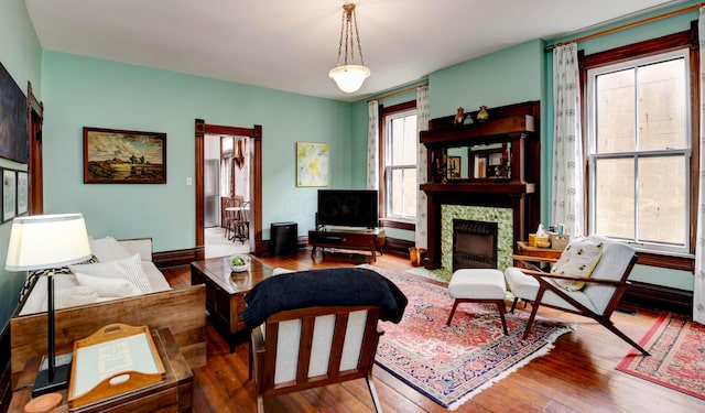 758 S Front St, Columbus, OH 43206 - living area featuring wood-type flooring, a tiled fireplace, and baseboards