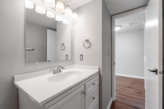 905 Soramill Ln, Columbus, OH 43085 - bathroom featuring a textured ceiling, wood finished floors, vanity, and baseboards
