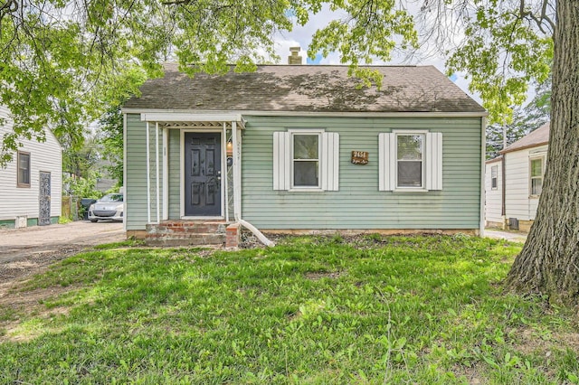 2454 Joyce Ave, Columbus, OH 43211 - cape cod home featuring a front lawn, a chimney, entry steps, and a shingled roof
