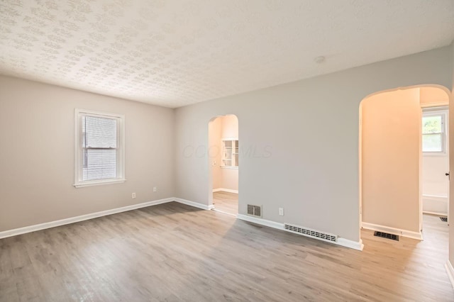 2454 Joyce Ave, Columbus, OH 43211 - unfurnished room with arched walkways, wood finished floors, and baseboards