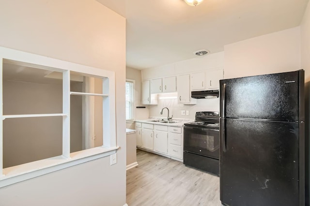 2454 Joyce Ave, Columbus, OH 43211 - kitchen with black appliances, under cabinet range hood, light wood-style flooring, and white cabinets