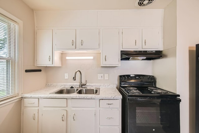 2454 Joyce Ave, Columbus, OH 43211 - kitchen with black range with electric cooktop, under cabinet range hood, a sink, white cabinets, and light countertops