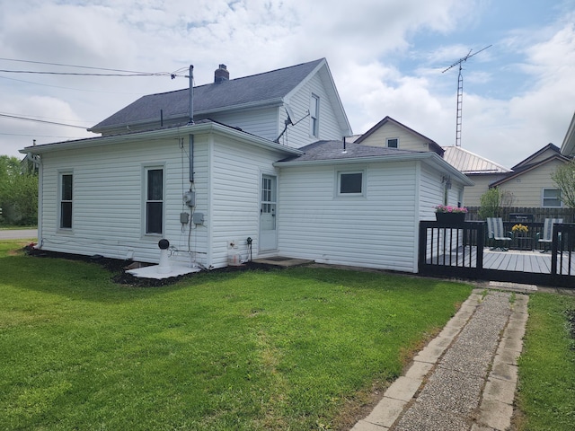 7703 County Road 91, Lewistown, OH 43333 - rear view of property featuring a deck, a lawn, and roof with shingles