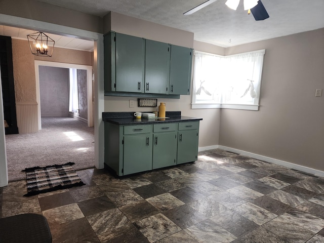 7703 County Road 91, Lewistown, OH 43333 - kitchen with green cabinets, baseboards, dark countertops, a ceiling fan, and dark stone finish flooring