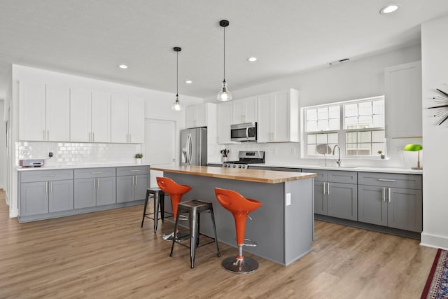 3918 Logan Ct, Hilliard, OH 43026 - kitchen with appliances with stainless steel finishes, butcher block countertops, gray cabinets, backsplash, and recessed lighting