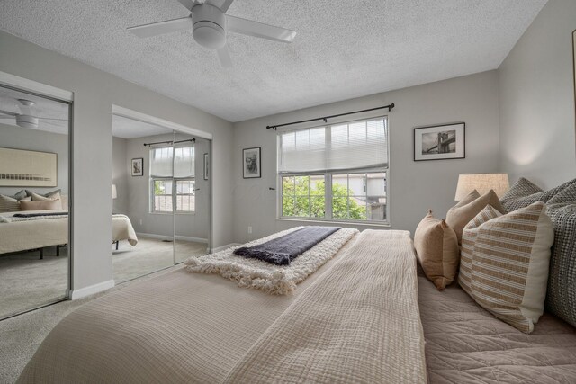 5394 Ambrosia Ave Unit 21B, Columbus, OH 43235 - bedroom featuring two closets, carpet floors, a ceiling fan, a textured ceiling, and baseboards