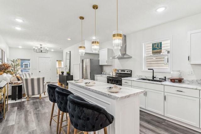 568 Wilson Ave, Marion, OH 43302 - kitchen featuring wall chimney exhaust hood, appliances with stainless steel finishes, a sink, a kitchen island, and dark wood-style flooring