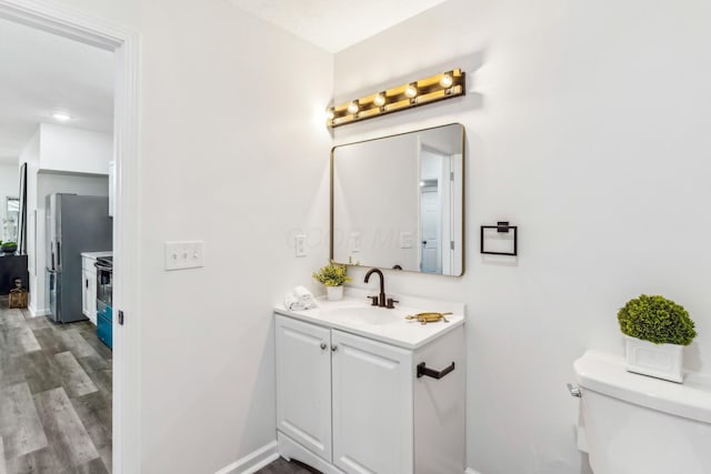 568 Wilson Ave, Marion, OH 43302 - bathroom featuring toilet, vanity, baseboards, and wood finished floors