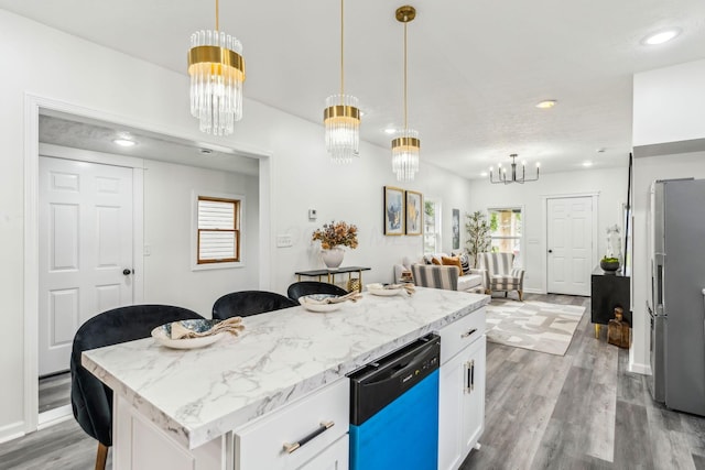 568 Wilson Ave, Marion, OH 43302 - kitchen featuring dishwashing machine, a chandelier, freestanding refrigerator, wood finished floors, and white cabinetry