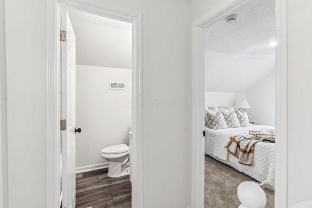 568 Wilson Ave, Marion, OH 43302 - ensuite bathroom with toilet, wood finished floors, baseboards, and lofted ceiling