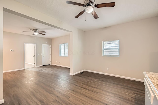 unfurnished room with ceiling fan, baseboards, and dark wood-style floors