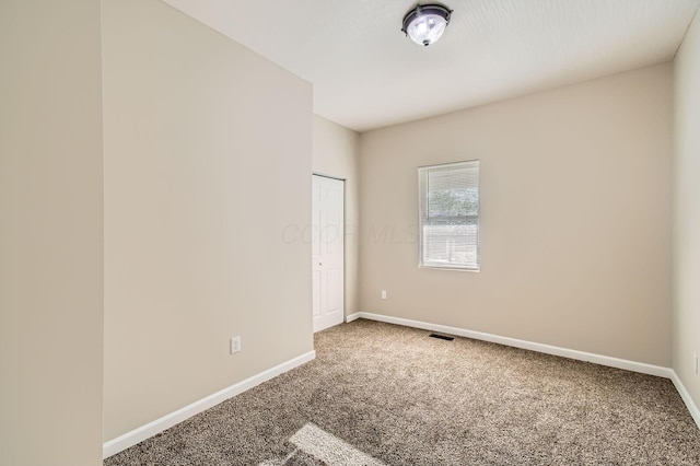 empty room with carpet and baseboards