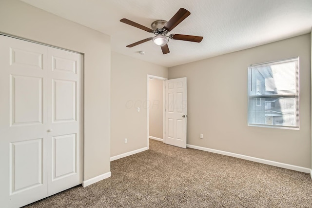 unfurnished bedroom featuring carpet flooring, baseboards, and a ceiling fan