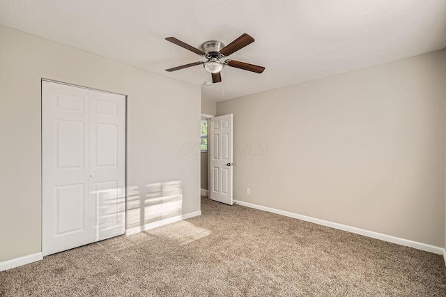 unfurnished bedroom with carpet flooring, baseboards, a closet, and ceiling fan