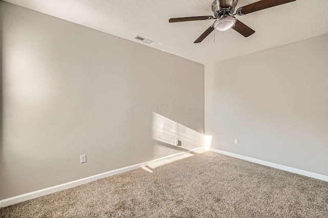 carpeted empty room featuring baseboards and ceiling fan