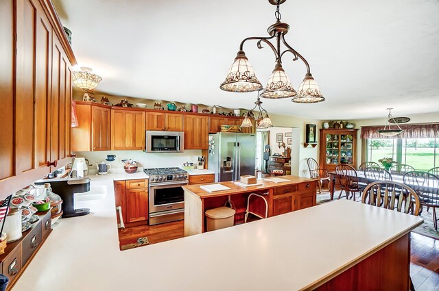 13742 State Rte 41, Jeffersonville, OH 43128 - kitchen featuring appliances with stainless steel finishes, light countertops, a kitchen island, decorative light fixtures, and dark wood finished floors
