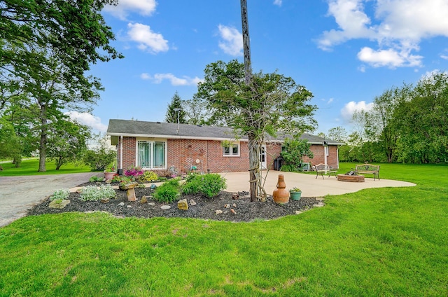 13742 State Rte 41, Jeffersonville, OH 43128 - view of front of home featuring a fire pit, brick siding, a front lawn, and a patio area