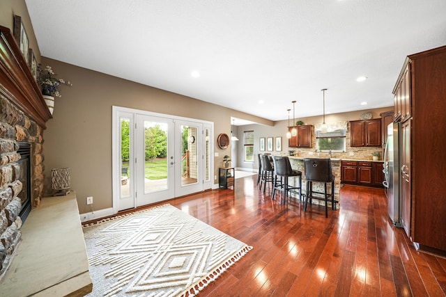 21252 Breckenridge Ln, Strongsville, OH 44149 - kitchen with light countertops, a breakfast bar area, a kitchen island, a fireplace, and dark wood-style flooring