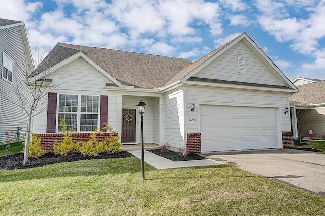 12281 Rooster Tail Dr, Pickerington, OH 43147 - view of front of property featuring driveway, a garage, brick siding, a front lawn, and roof with shingles