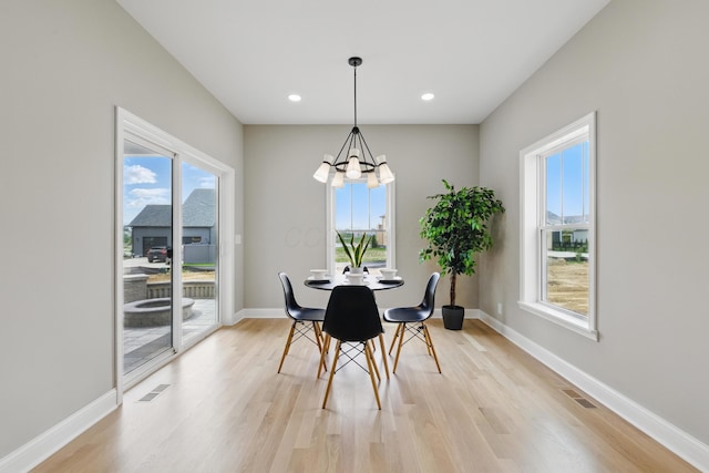 dining space featuring light wood-style flooring, a chandelier, baseboards, and recessed lighting