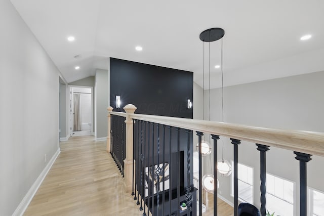hall featuring wood finished floors, recessed lighting, vaulted ceiling, an upstairs landing, and baseboards