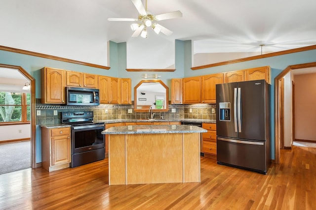 4217 Caswell Rd, Johnstown, OH 43031 - kitchen featuring stainless steel appliances, a sink, vaulted ceiling, decorative backsplash, and light wood-style floors