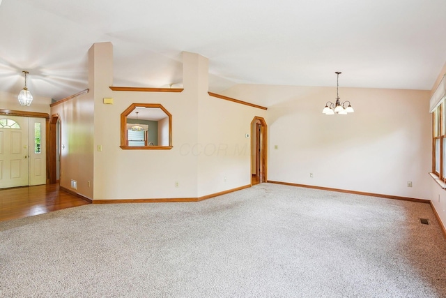 4217 Caswell Rd, Johnstown, OH 43031 - unfurnished living room with carpet flooring, a chandelier, baseboards, healthy amount of natural light, and lofted ceiling