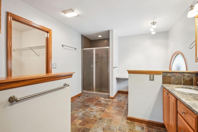 4217 Caswell Rd, Johnstown, OH 43031 - full bath featuring baseboards, a stall shower, stone tile flooring, vanity, and a spacious closet