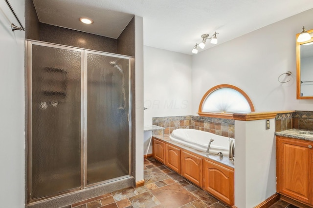 4217 Caswell Rd, Johnstown, OH 43031 - full bathroom featuring a shower stall, a garden tub, stone finish floors, vanity, and baseboards