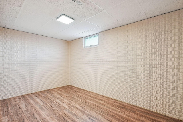 4217 Caswell Rd, Johnstown, OH 43031 - basement with a drop ceiling, wood finished floors, and brick wall