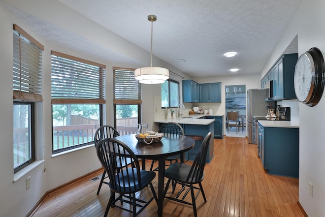 587 Center Woods Dr, Columbus, OH 43214 - dining room with light wood-style flooring, baseboards, and a textured ceiling