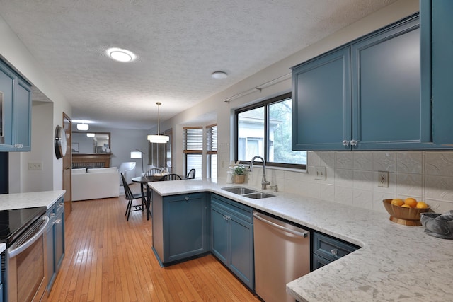 587 Center Woods Dr, Columbus, OH 43214 - kitchen with a sink, appliances with stainless steel finishes, blue cabinets, decorative backsplash, and light wood-type flooring