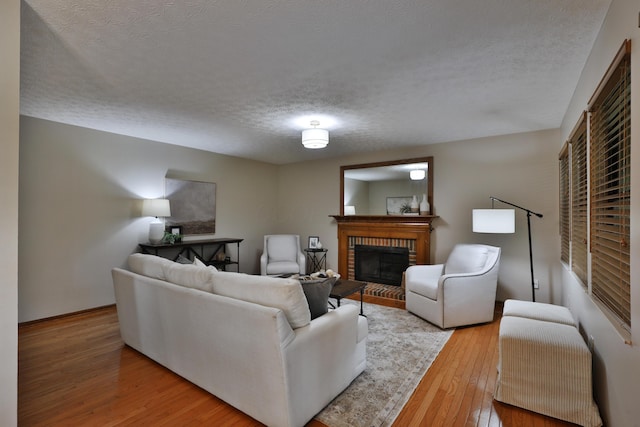 587 Center Woods Dr, Columbus, OH 43214 - living area featuring a brick fireplace, a textured ceiling, hardwood / wood-style floors, and baseboards