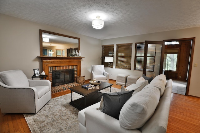 587 Center Woods Dr, Columbus, OH 43214 - living area with a textured ceiling, wood finished floors, and a brick fireplace